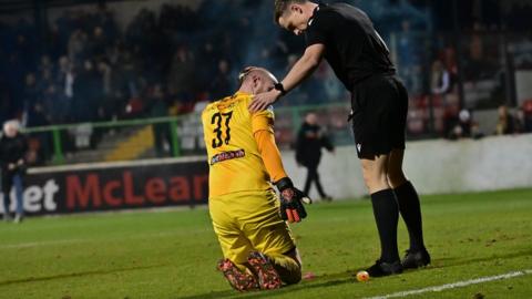 Glentoran goalkeeper Aaron McCarey is hit by an object thrown from the crowd at the Oval