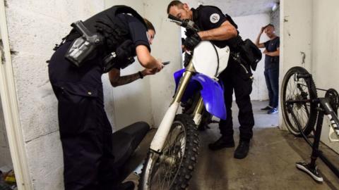French police officers inspect a motorcycle in the cellars of a building during a law enforcement operation to counter motorcycle rodeos, in Nantes, western France on August 11, 2022