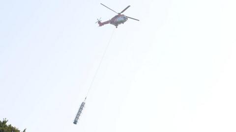 Helicopter carrying part of the tower