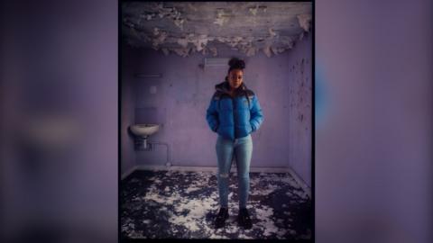 Tia stands in former cell block and features in the exhibition