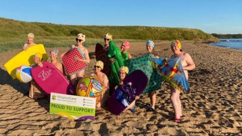 A group of Women's Institute members posing on the beach