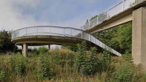 Concrete bridge showing spiral steps and ramp from ground level to the overbridge