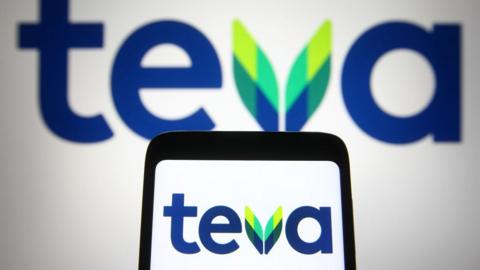 In this photo illustration, a Teva logo of an Israel pharmaceutical company seen displayed on a smartphone and a pc screen