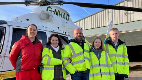 People standing by a helicopter