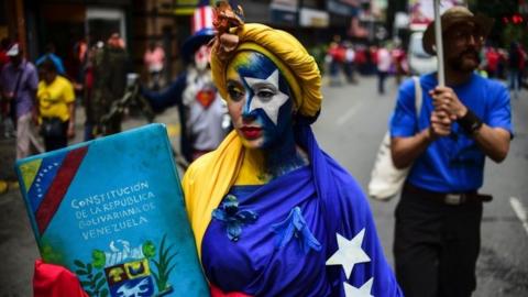 Pro-government activists demonstrate their support to the government of Venezuelan President Nicolas Maduro and against US President Donald Trump, in Caracas, on August 14, 2017.