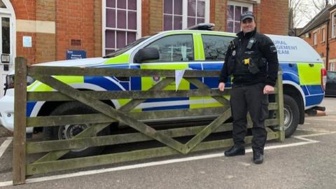 Police officer poses with the gate after it was recovered