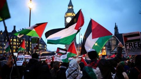 Protesters wave Palestinian flags outside the UK parliament on 21 February