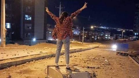 Photo posted online reportedly showing a young woman stands on a dumpster on a street in Sanandaj, western Iran, during an anti-government protest