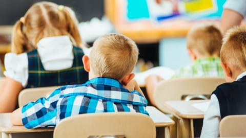 Boy sits in classroom