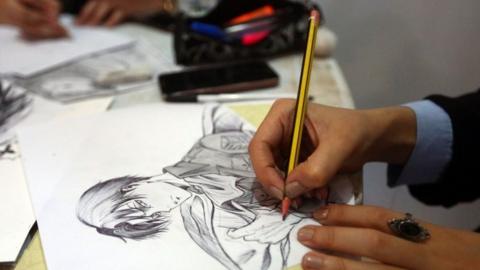 An artist draws an illustration at a stall during the Libya Comic Convention, in the capital Tripoli (02 November 2017)