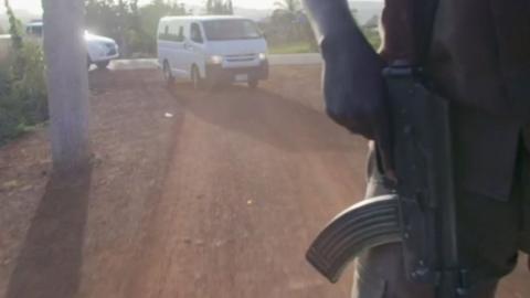 cars driving and an armed man riding a vehicle