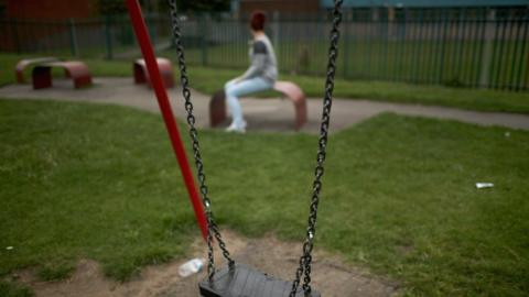 Teenage girl nears a swing