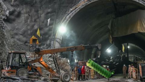 A crane carries a part of drilling machine as rescue operation enters its final phase, for workers trapped in the Silkyara under construction road tunnel, days after it collapsed in the Uttarkashi district of India's Uttarakhand state on November 22, 2023. Indian rescuers have drilled two-thirds of the way through debris towards 41 workers trapped in a collapsed road tunnel, officials said on November 22, warning that the next 24 hours could be critical. (Photo by Arun SANKAR / AFP) (Photo by ARUN SANKAR/AFP via Getty Images)