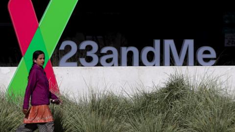 A pedestrian walks by a sign posted in front of the 23andMe headquarters in Sunnyvale, California.