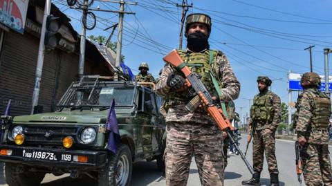 Paramilitary troopers stand alert during a shutdown against the killing of tourists at a famous tourist resort Pahalgam