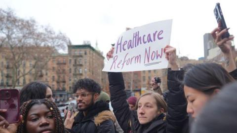  Demonstrators stand outside the federal court after Luigi Mangione, suspect in the killing of UnitedHealthcare CEO Brian Thompson, during an arraignment hearing on December 19, 2024 in New York City. One woman holds a sign that reads: Healthcare Reform Now.