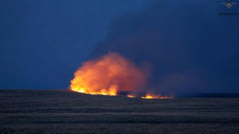 A night-time image of a large fire on Salisbury Plain against an inky blue sky in Wiltshire. 