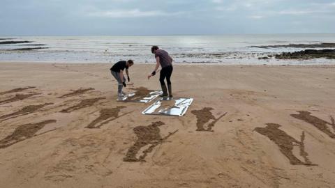 Installing figures of soliders onto a beach in Broadstairs 