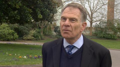 Christopher Scholefield being interviewed in a park