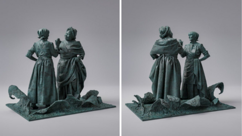 A bronze statue which depicts an enslaved black woman clasping hands with a white mill worker