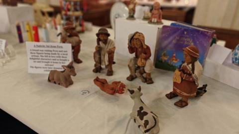 A nativity scene from Peru. It has figurines wearing traditional Peruvian clothing. 