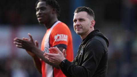 Matt Bloomfield claps towards the Luton fans after their win against Portsmouth