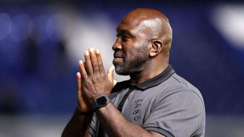 Port Vale manager Darren Moore applauds his side's supporters at St Andrew's after their Carabao Cup win over Birmingham City.