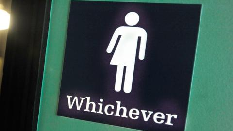 A bathroom door with a gender neutral sign saying "Whichever"