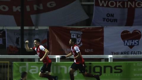 Woking celebrate a goal against Dagenham and Redbridge