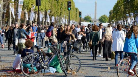 Pedestrians and cyclists on the Champs Elysées during the 2016 car-free day organised in Paris on September 25, 2016