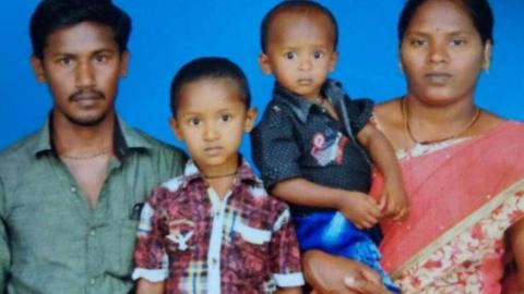 Sujith on his mother's arm with his brother and father
