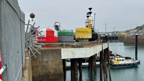 A pier with various marine equipment on it.