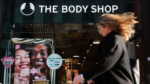 Woman walks pasts The Body Shop