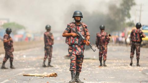 Border Guards Bangladesh (BGB) personnel secure a highway as activists from Hefazat-e Islam block a road during a nationwide strike following deadly clashes with police over Indian Prime Minister Narendra Modis visit, in Narayanganj, about 16 kms southeast of Dhaka on March 28, 2021.