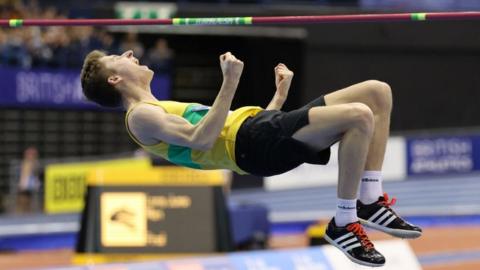 Tom Hewes punches the air in celebration at a winning jump