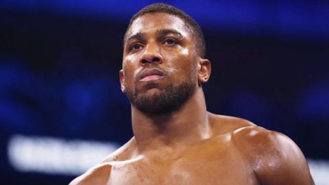 A close-up of Anthony Joshua in the ring, staring into the distance