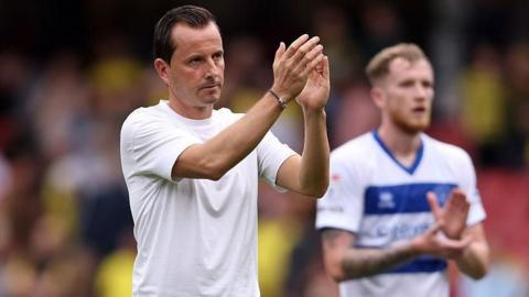 Julien Stephan applauds the QPR fans with Liam Morrison in the background
