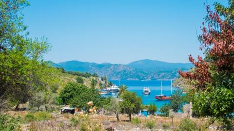 Panoramic view from an island to a bay with luxury yachts and sailing boats on May 25, 2014 in the Gulf of Fethiye, Lycian Coast, South of Turkey