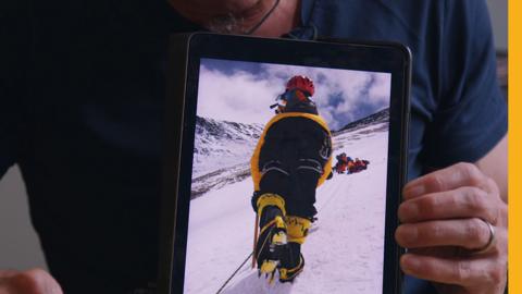 Mountaineer wearing crampons the wrong way around