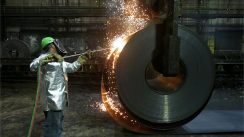 A worker cuts a piece from a steel coil at the Novolipetsk Steel PAO steel mill in Farrell, Pennsylvania, U.S.,