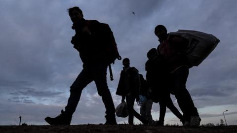 A group of migrants and refugees walk to Pazarkule Border gate during the sunset at the city center of Edirne, Turkey, 04 March 2020.