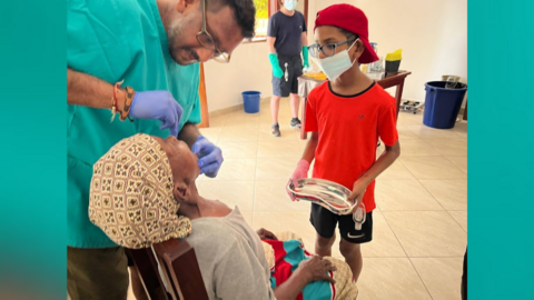 Dr Vivak Shah treats a patient as one of his sons standby to help