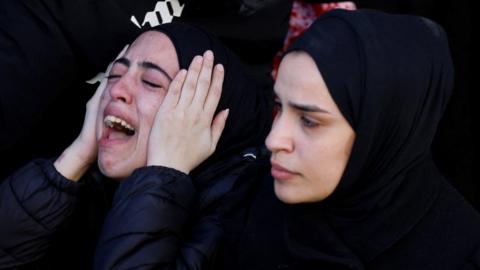 The daughter of 57-year-old teacher Jawad Bouaqneh reacts as mourners carry his and 28-year-old militant Adham Jabareen's bodies during their funeral in Jenin, in the occupied West Bank (19 January 2023)