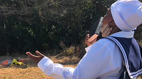 A woman praying at the site of where one of the victims was found in Mthwalume, South Africa