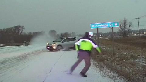 Sliding car narrowly misses US police officer