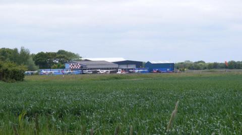 A picture of the airfield at Beccles, Suffolk, showing light aircraft and hangars