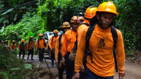 Men from the Department of Disaster Prevention and Mitigation arrive to the cave entrance in Chiang Rai, Thailand, 6 July 2018