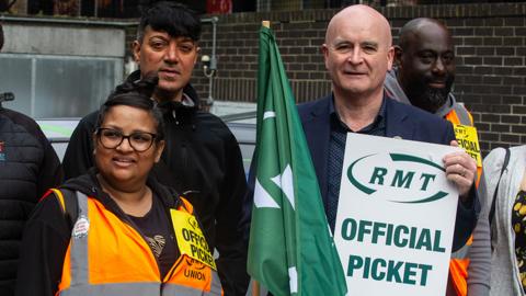 General secretary Mick Lynch joins striking RMT members attending their picket line on September 2, 2023 in London, England. The picture includes Mick on the right holding an RMT sign, with a few other members pictured alongside.