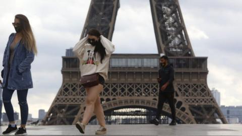 People wear face masks near the Eiffel Tower in Paris, France, 23 September 2020