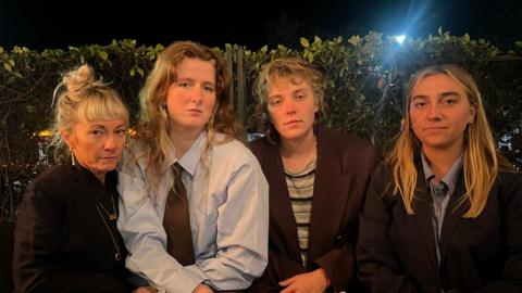 Four women, all looking at camera